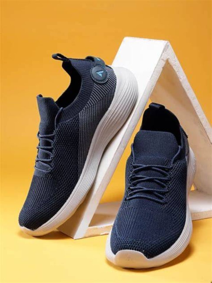 A pair of navy running shoes with teal, purple, and pink accents.