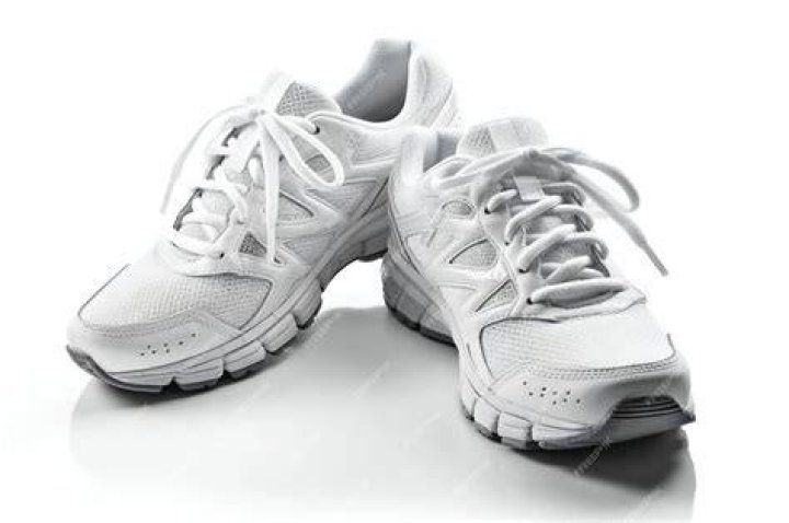 A pair of white running shoes with neon yellow and black accents.