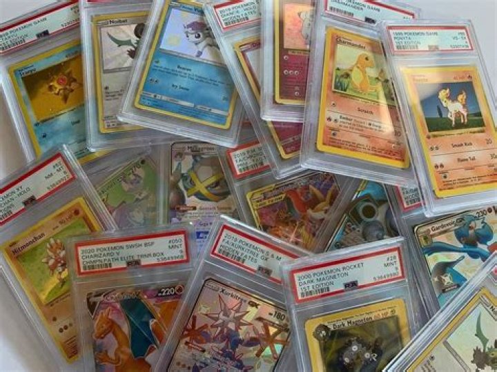 A pile of graded Pokemon cards strewn haphazardly.