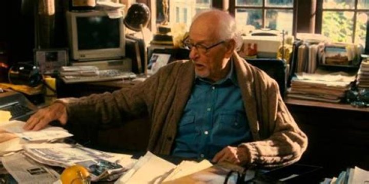Arthur at his desk shuffling through paperwork on The Holiday