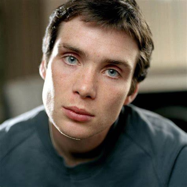Cillian Murphy sitting in a leather chair during a hearing in Oppenheimer.