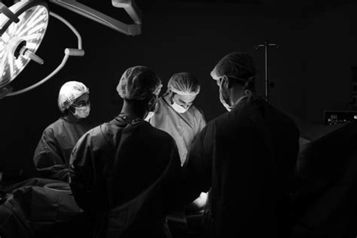doctors and surgeons in dark OR
