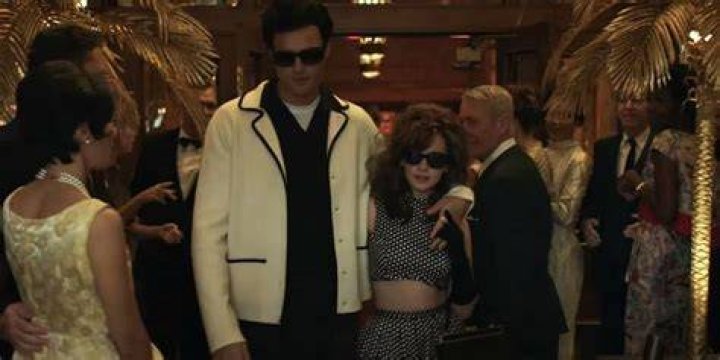 Elvis and Priscilla walk through a crowd in Priscilla