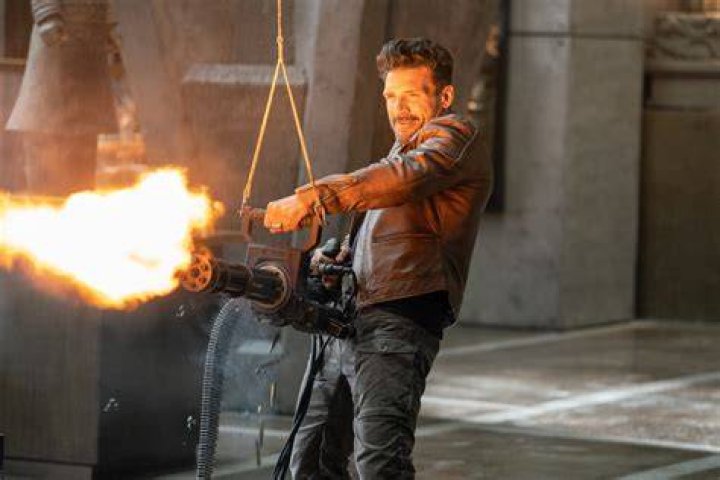 Frank Grillo firing a mini-gun in Boss Level (2021)