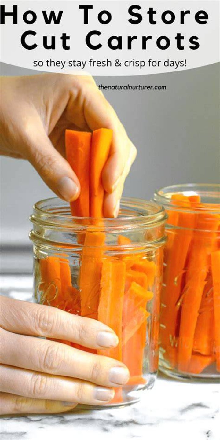 fresh and cut carrots on wooden board