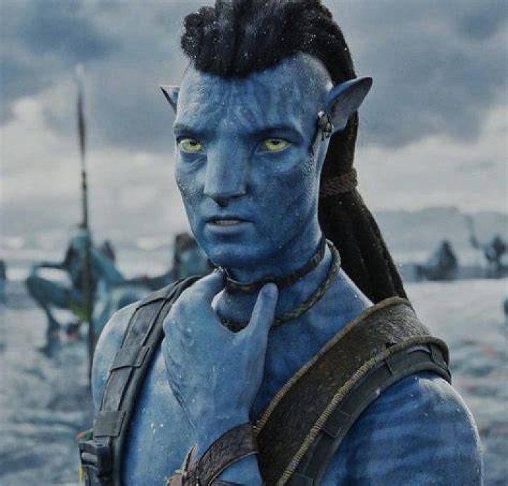 Jake Sully and his child by the well-lit water in Avatar 2