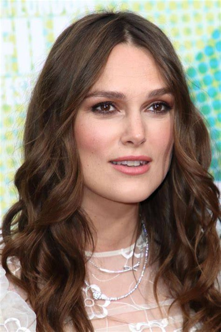 Keira Knightley looking intently at something with Kelly Reilly standing behind her in Pride and Prejudice