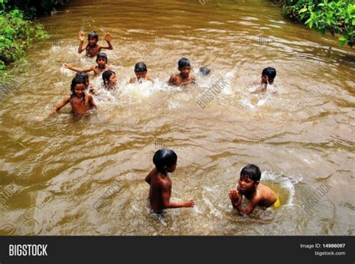 kids bathing in a river in delhi, india