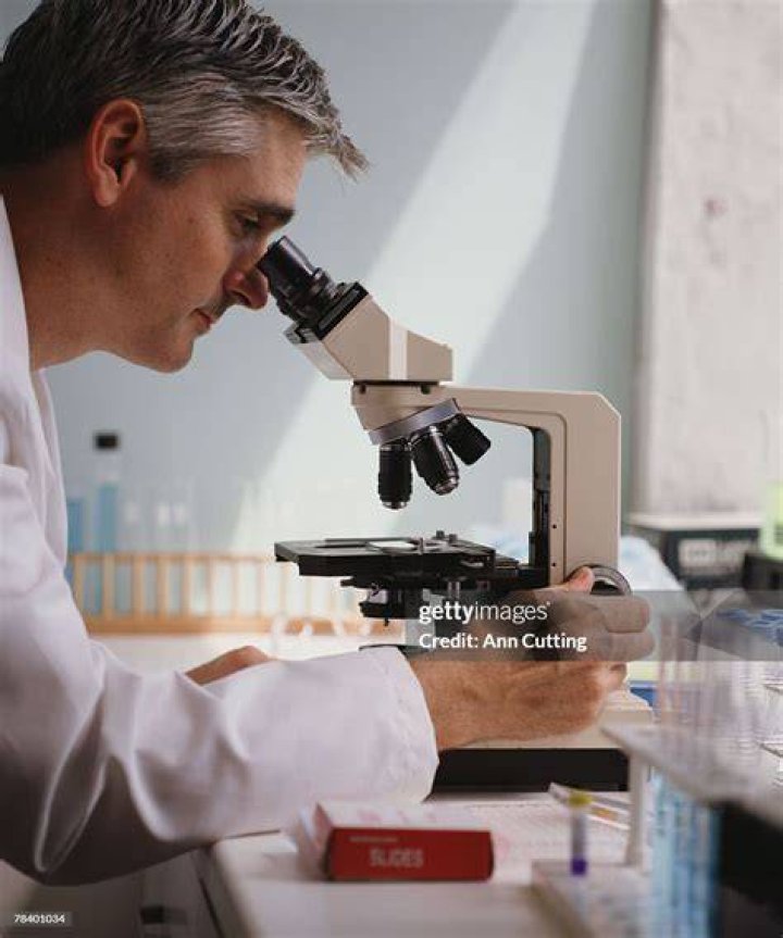 man looking into microscope