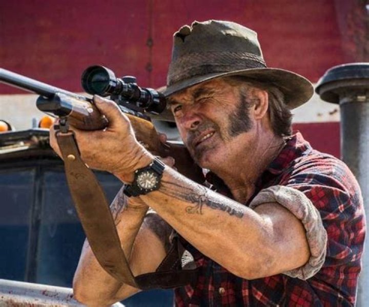 Mick Taylor aiming a rifle in Wolf Creek