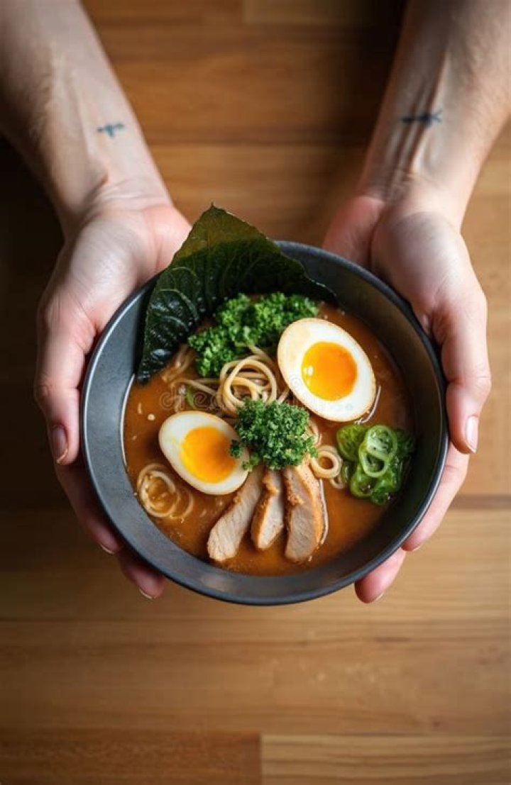 person holding bowl of ramen in vietnam