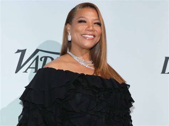 Queen Latifah sitting across from Will Smith in a scene from The Queen Latifah Show.