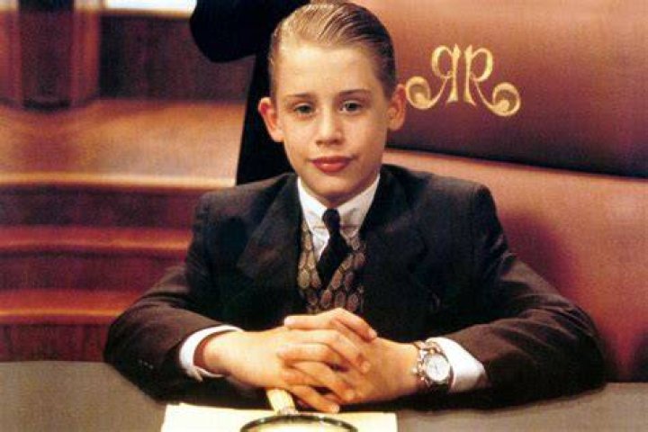 Richie Rich wearing a suit and sitting behind his desk