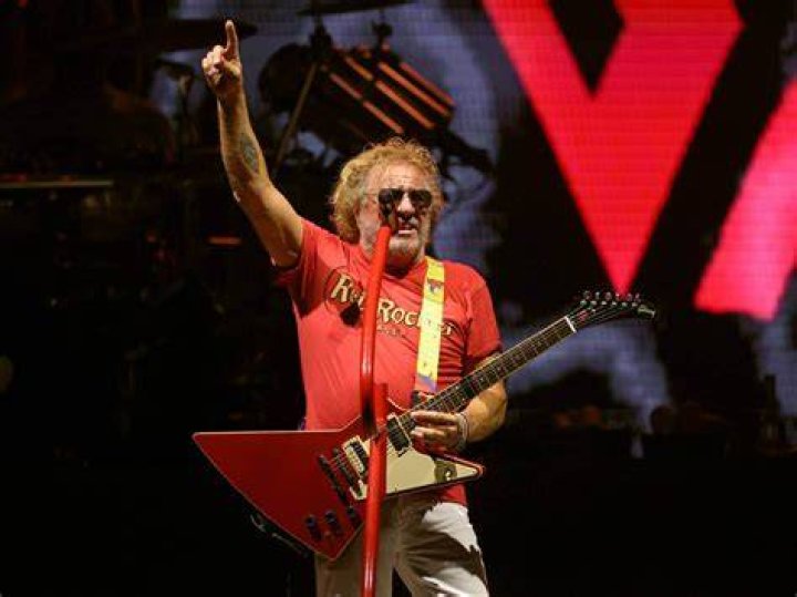 Sammy Hagar in a demim jacket and Eddie Van Halen in a red shirt and baggy blue pants