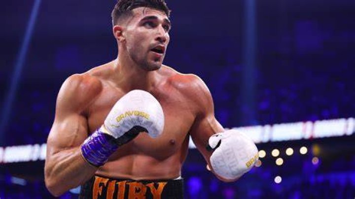Tommy Fury holds up a glove during a boxing match