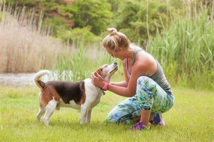 woman petting dog on a leash