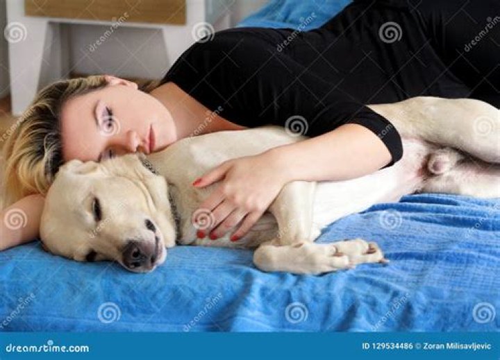 woman sleeping with her dog on the couch