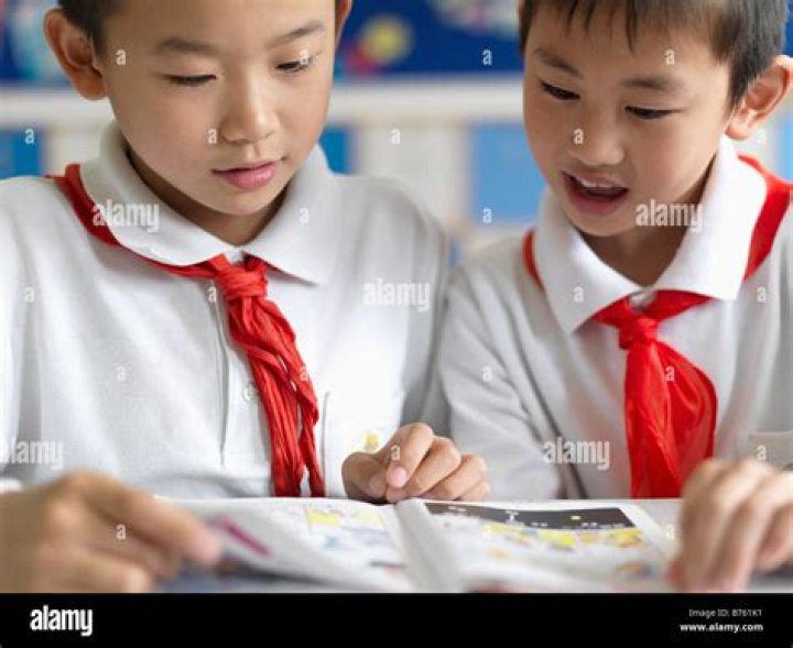 Young Chinese school boys peeking in through a window